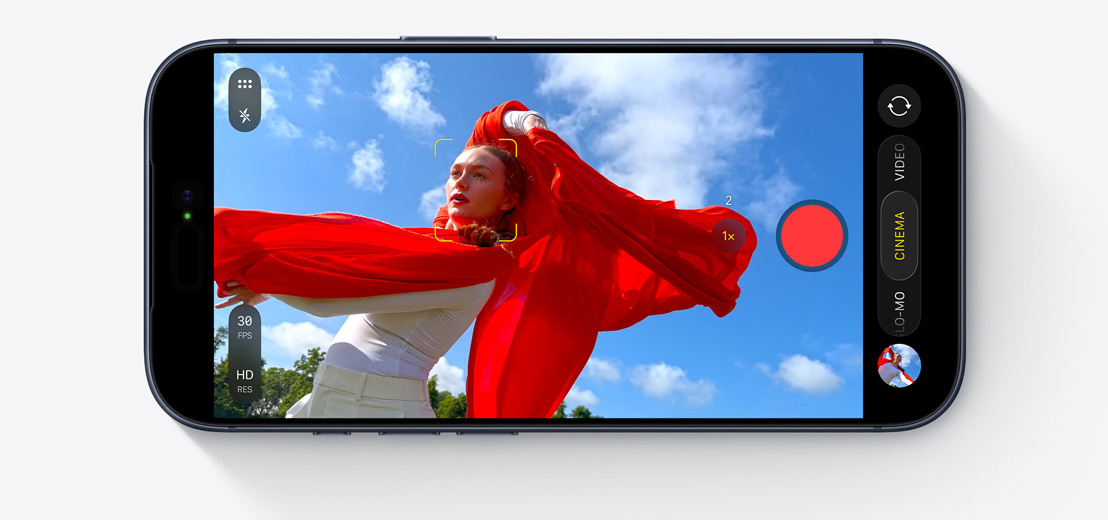 Lo schermo di un iPhone mostra la modalità Cinema durante la ripresa di una persona che balla all’aperto indossando una sciarpa rossa