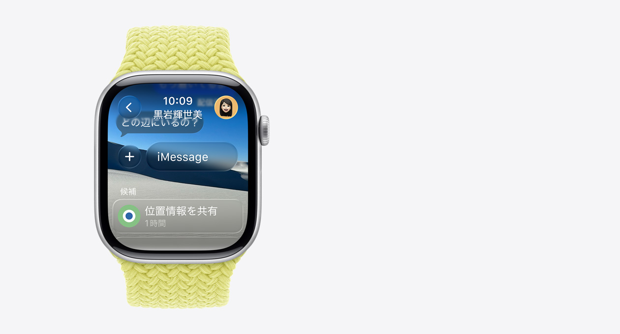 シルバーのApple Watchとイエローのブレイデッドバンド。画面に「どの辺にいるの？」という半透明のメッセージが表示され、下部には「候補」というテキストとともに「1時間位置情報を共有」というスマートアクションが表示されている