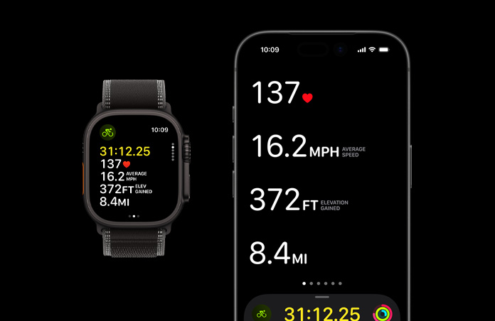Apple Watch Ultra 3 med urkasse av svart titan og Trail Loop i svart/koksgrå vises ved siden av en iPhone. Målinger fra en aktiv treningsøkt vises på begge enhetene.