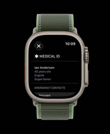 Apple Watch Ultra 3 med urkasse av naturlig titan og Trail Loop i grønn/neon viser Nødinfo på skjermen.