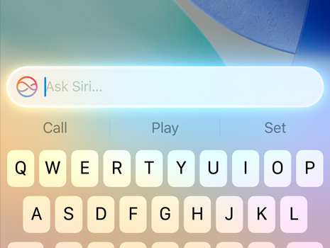 macOS Tahoeを背景に、Siriにリクエストしているカーソルのクローズアップ